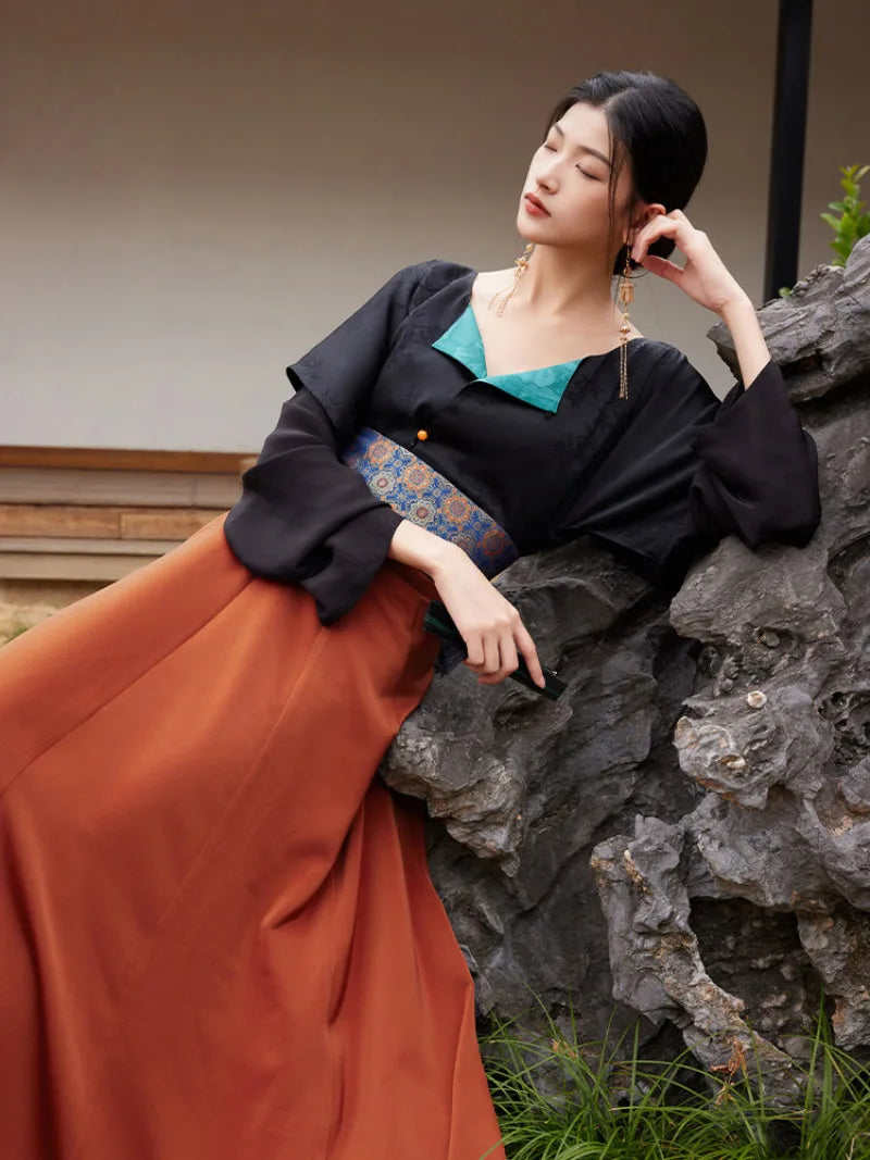 Model holding out the rust-orange hanfu skirt to show its wide flowing panels