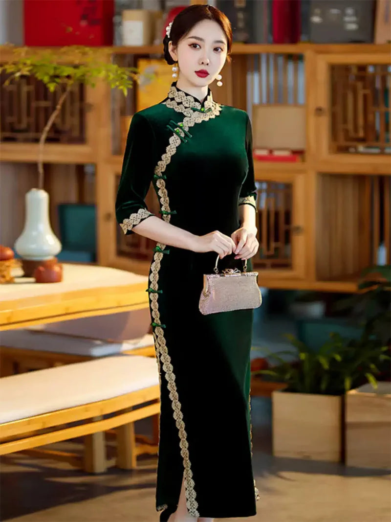 Lace edged velvet cheongsam in emerald green with lace trim and jade frog buttons
