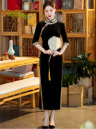 Lace edged velvet cheongsam in emerald green with lace trim and jade frog buttons