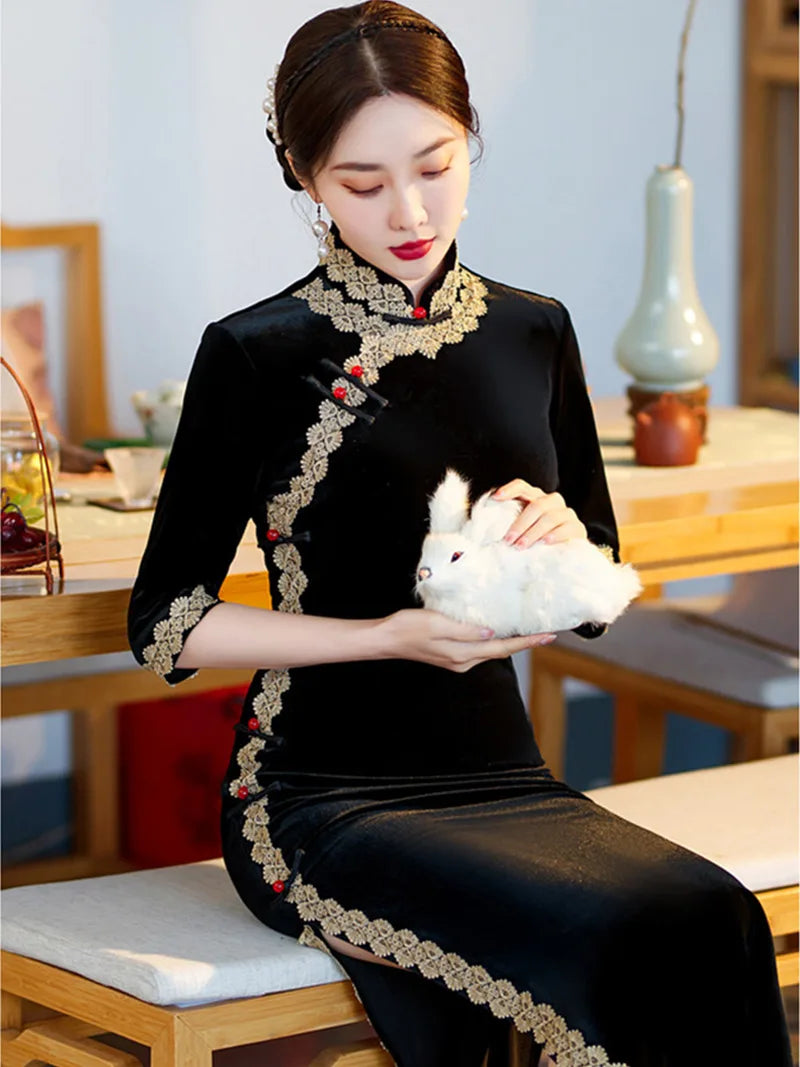 Lace edged velvet cheongsam in emerald green with lace trim and jade frog buttons