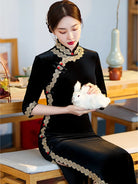 Lace edged velvet cheongsam in emerald green with lace trim and jade frog buttons