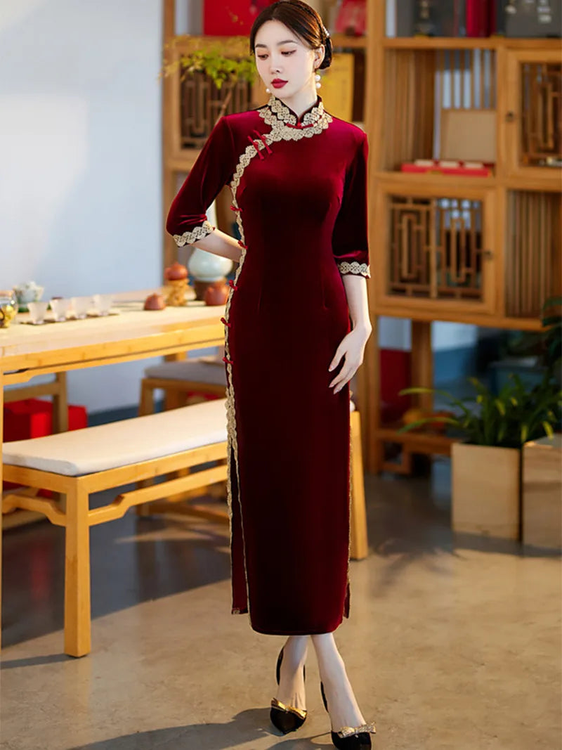 Lace edged velvet cheongsam in emerald green with lace trim and jade frog buttons