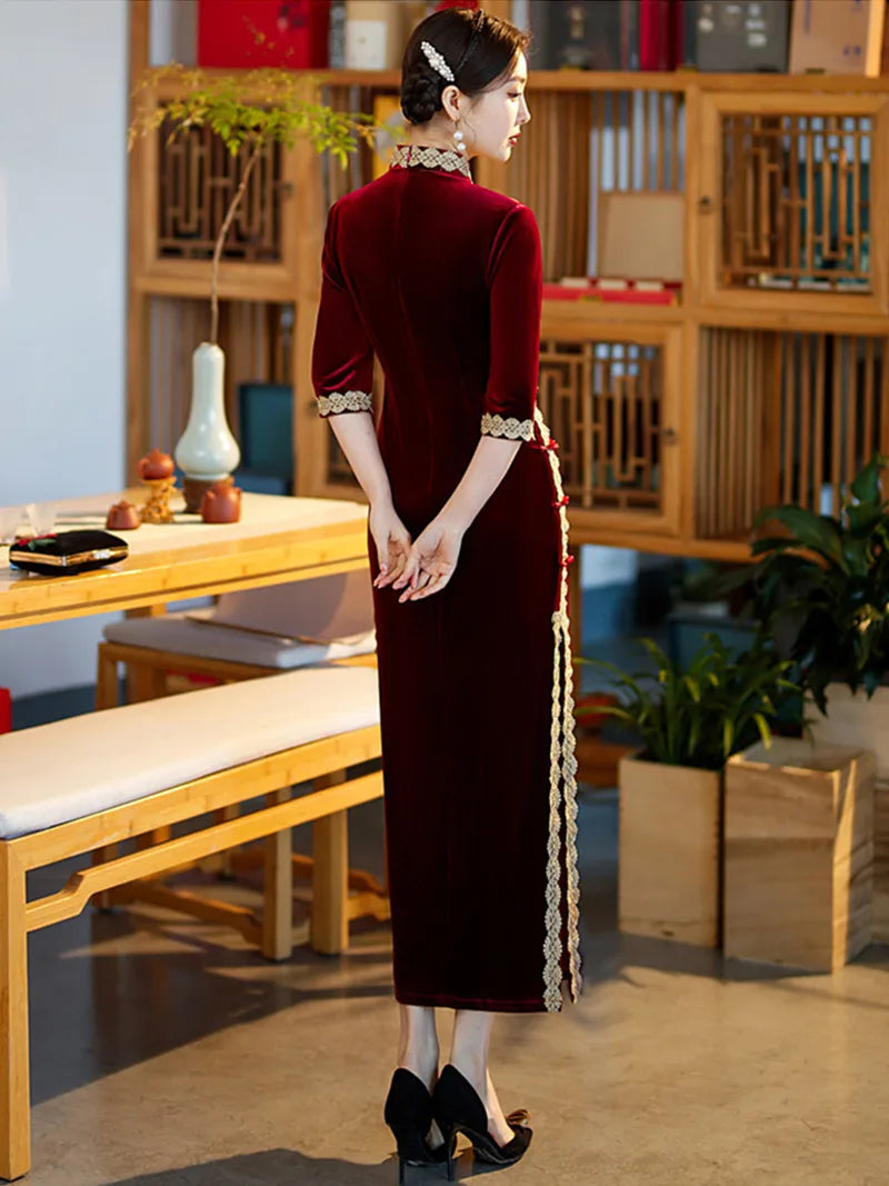 Lace edged velvet cheongsam in emerald green with lace trim and jade frog buttons