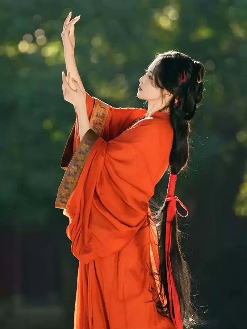 Red Chinese hanfu dress with trailing hem inspired by Warring States robe, featuring wide sleeves and traditional elegance