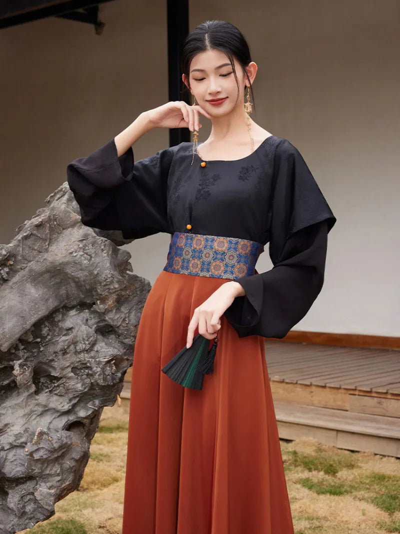 Model holding out the rust-orange hanfu skirt to show its wide flowing panels