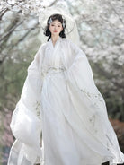 White hanfu outfit for women with wide sleeves and cross-collar design in ethereal traditional Chinese style